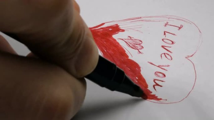 一个年轻人的手的特写镜头他用红笔在纸上写下我爱你的话