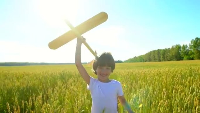 日落时，快乐的小男孩在麦田里用玩具飞机奔跑。孩子在户外夏天玩飞机。小飞行员梦想着飞行，和幸福的家人一