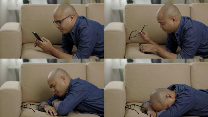 年轻的亚洲男子躺在客厅的沙发上，使用智能手机。他因过多地看智能手机屏幕而感到疲倦。