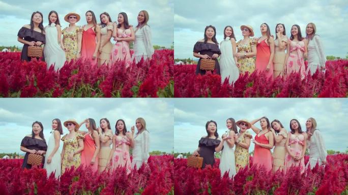 一群beatuful迷人的亚洲女性朋友穿着休闲装站在一起聊天，在红花农场欢乐快乐的天空背景旅行概念