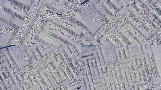 装饰迷宫中雪中人脚的痕迹。鸟瞰图。冬天阳光明媚的寒冷日子里，城市公园在雪地里。自然和新鲜空气。冬季背