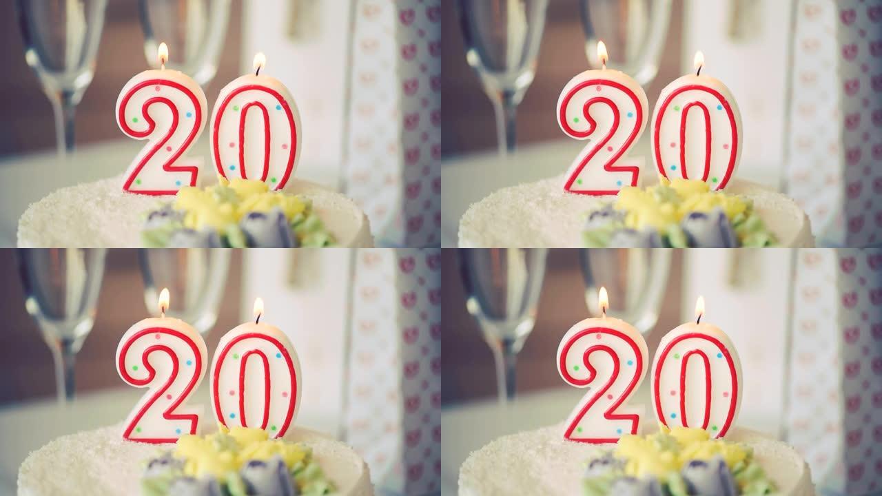 生日蜡烛作为20号20在桌上的甜蛋糕上，20岁生日