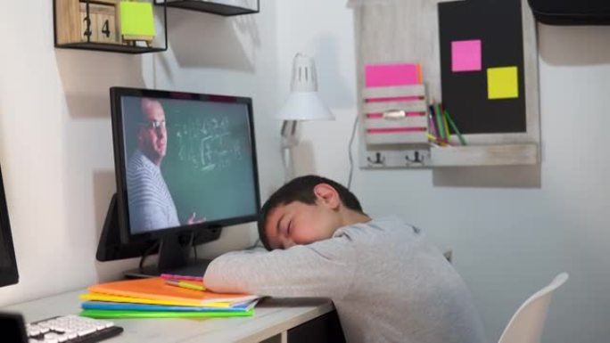 一个男孩在网上上课时小睡一会儿。在线教育、家庭教育、技术、学校的概念