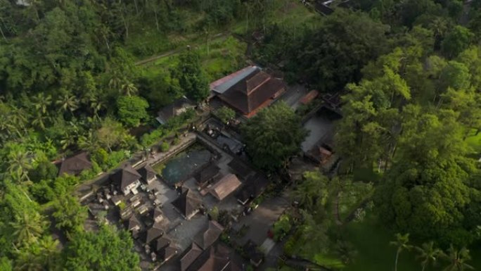 空中倾斜到印度教巴厘岛Tirta Empul水庙的俯视图中，带有用于沐浴的圣泉水塘