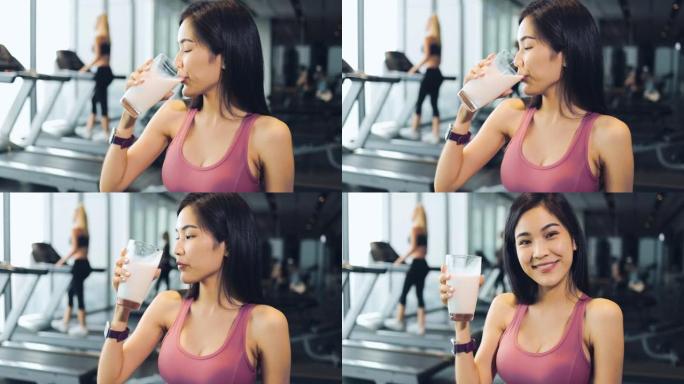 年轻的亚洲妇女在健身房锻炼后喝蛋白质奶昔