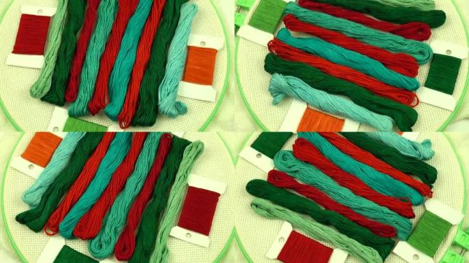 红色和绿色调的绣花线排列在带有帆布的绣花环上