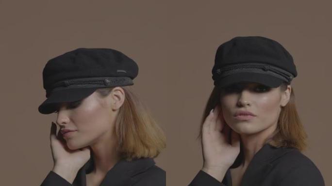 一个穿着黑色帽子和带有眼妆的夹克的短发的美丽女孩用手抚摸着她的脸。垂直格式视频。