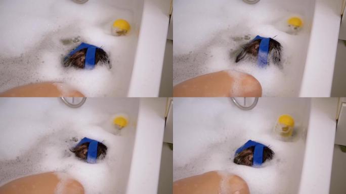 快乐男孩用泡沫洗澡，戴着潜水面具在水下潜水