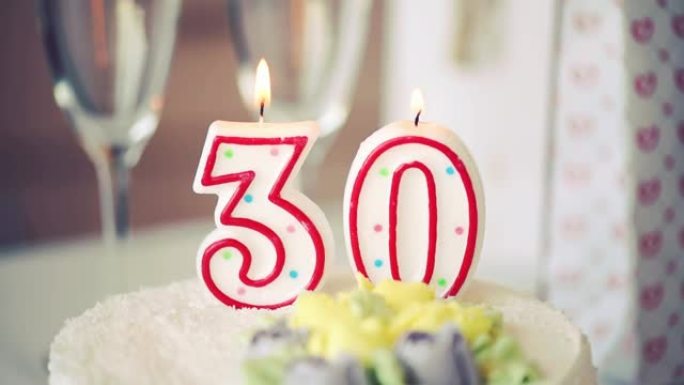 生日蜡烛作为30号30在桌上的甜蛋糕上，30岁生日