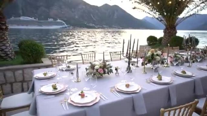 婚礼宴会上的一张桌子，上面装饰着鲜花，烛台和年轻的石榴在科托尔湾的码头上