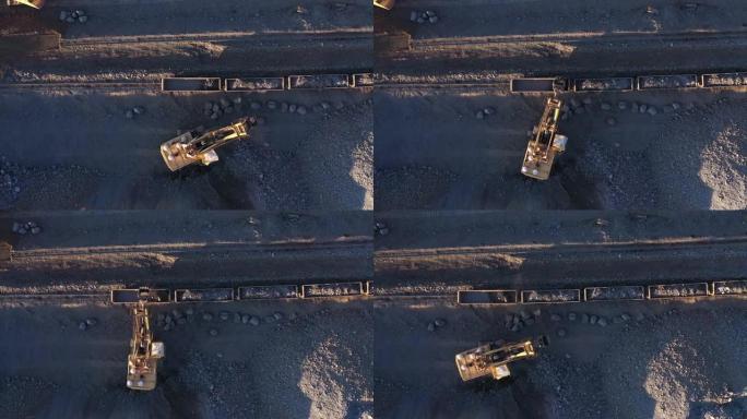 挖掘机将矿石装入货车的空中俯视图。