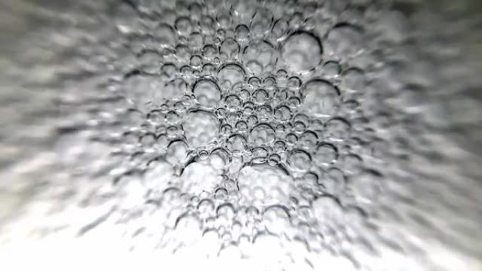 极端特写慢动作镜头，在一杯水中形成气泡，当它充满时