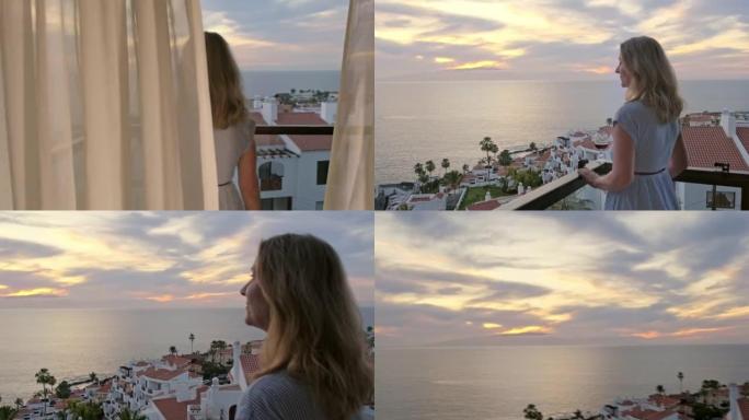 迷人的金发女人打开窗帘，走到阳台上，欣赏海洋上美丽而浪漫的日落美景