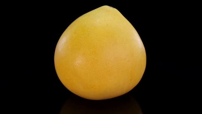 柚子果实在黑色背景上旋转。新鲜，完美，有机充满活力的4K黄柚。