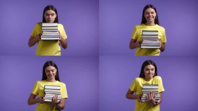 紫罗兰色背景下的微笑女人拿着一堆图书馆的大学书籍。女孩笑了，她很高兴毕业。