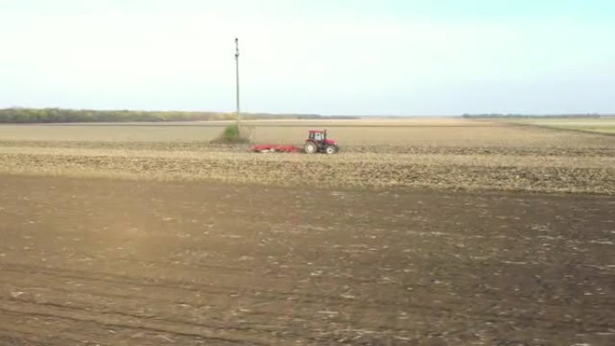 拖拉机在农田，农田上拖动圆盘耙时的空中横向行进视图