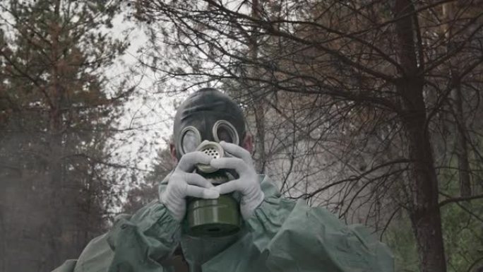 剂量计的Chornobyl清洁剂的肖像，在烟雾和森林的背景下在雨林中的防毒面具。1986年4月26日