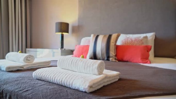 在自然光线充足，整洁的现代卧室中，放大放在床上的枕头。