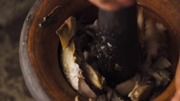 有人用研钵和研杵粉碎鱼肉。准备做鱼浆。泰国菜菜单。