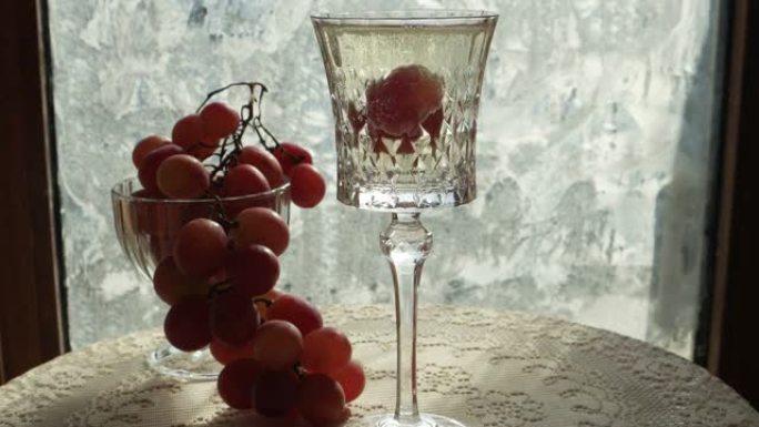 将葡萄浸入一杯香槟酒中，并以冰花为背景。