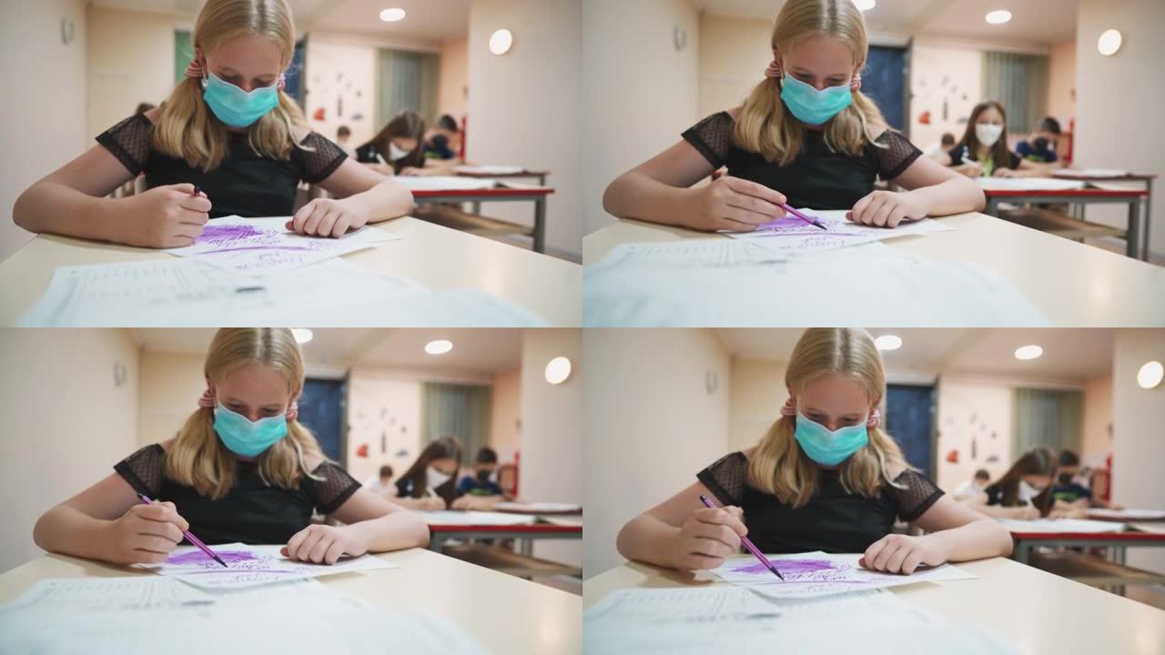 带防护面具的女学生在小学美术课上画画