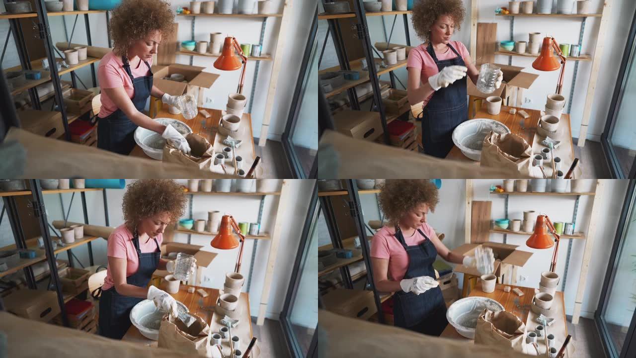 Craftwoman在她的工作室为新的混凝土锅准备混合物