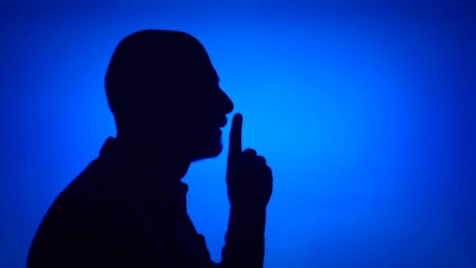 高级男子在蓝色背景上做沉默手势的剪影。神秘和保密的概念