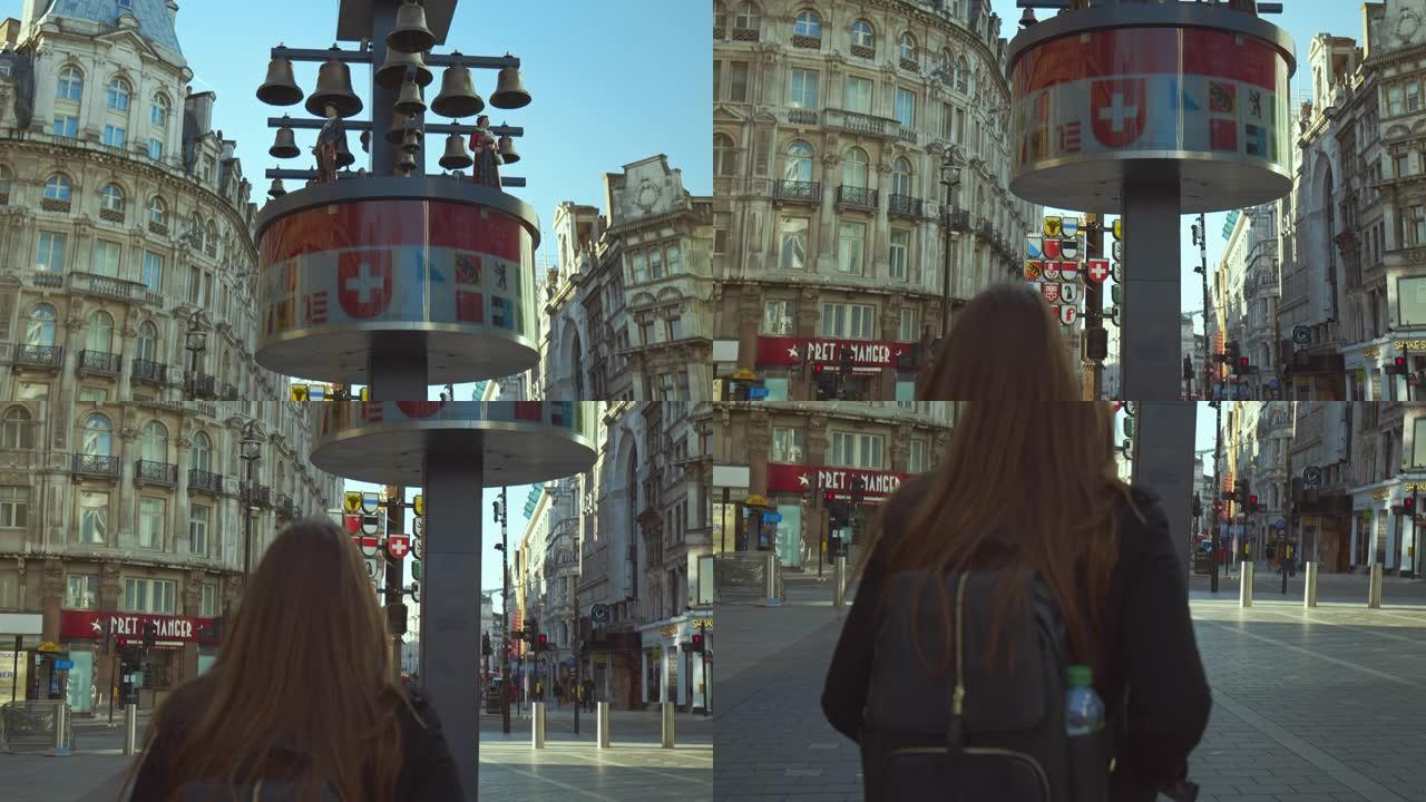一个穿着外套背包的旅游女孩在英国伦敦莱斯特广场散步。