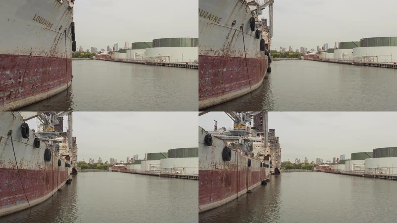 揭示了停泊在港口的旧生锈货船后面的纽约市港口和红钩谷物码头