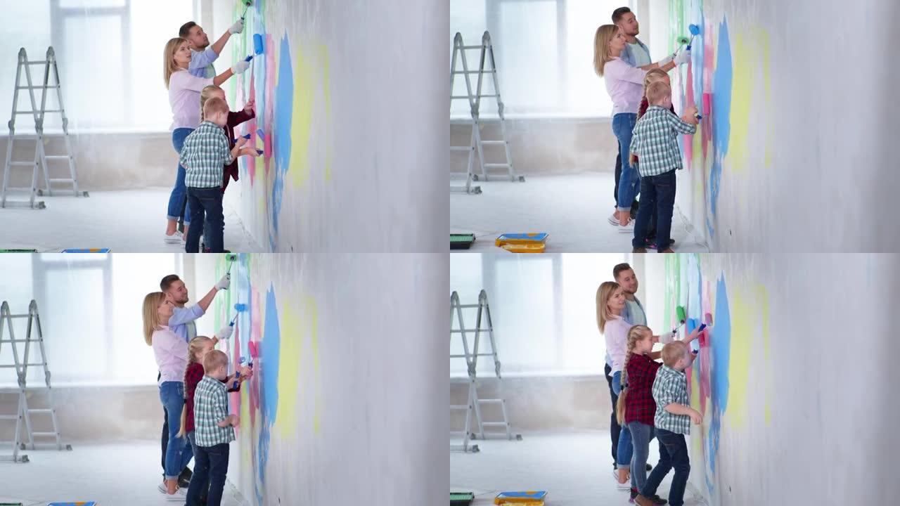 开朗的男女父母唐氏综合症男孩和女孩在装修时在室内用彩色油漆油漆墙壁，微笑着看着相机