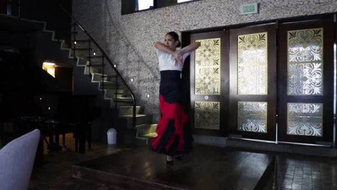 西班牙弗拉明戈舞者在餐厅的木制舞台上跳舞。年轻的女孩。