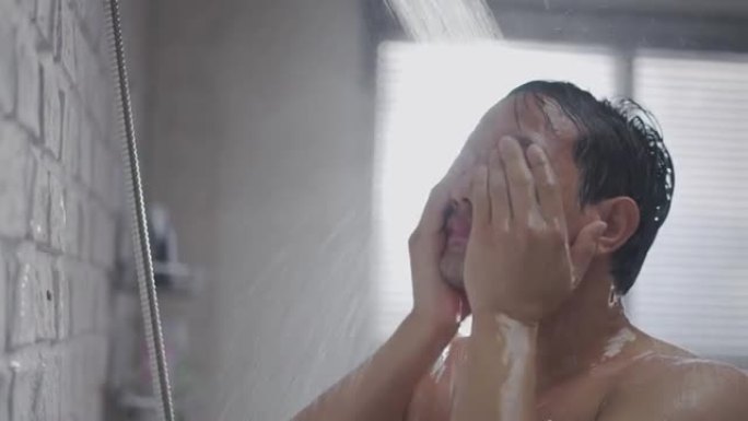 英俊的亚洲男人在浴室洗澡，他正在洗头