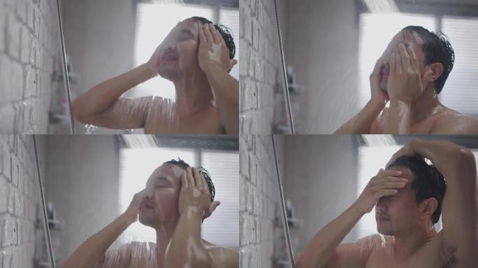 英俊的亚洲男人在浴室洗澡，他正在洗头