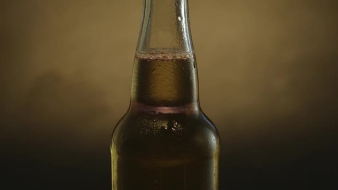 一瓶冰啤酒在黑暗的背景下缓慢旋转。冷光啤酒特写。360度旋转