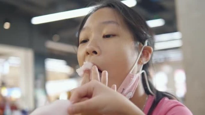 快乐的亚洲儿童交谈，享受棉花糖和一些小吃，一起在美食广场与家庭，生活方式的概念。