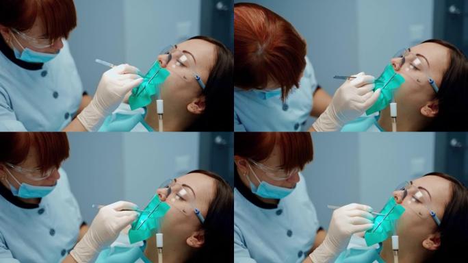 牙科椅上戴着防护眼镜的病人的脸。在牙科中心治疗女性牙齿的专业口腔科医生。口腔医学概念。
