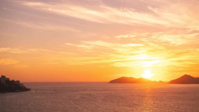 在多山的日落和晴朗的天空与夕阳中，可以看到宁静的海洋的美丽景色。日落视频概念。度假概念。