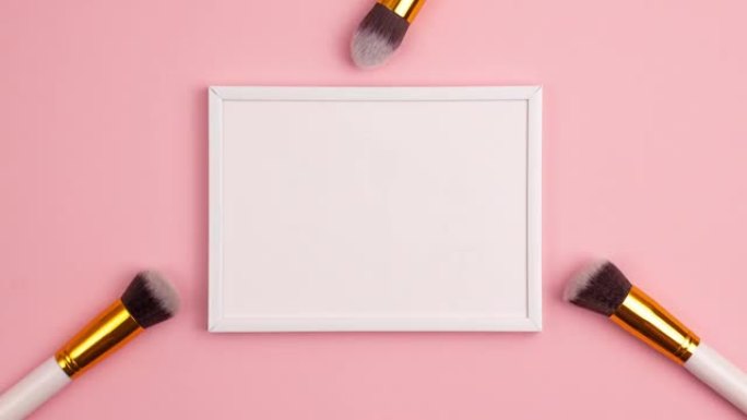 停止运动动画模型木制相框顶部视图化妆刷设置在粉红色背景上。化妆品和美容概念模板化妆概念与复制空间平铺