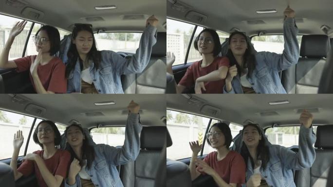 亚洲女性朋友听音乐摇摆身体，享受车内; 慢动作