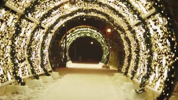 公园里五颜六色的发光圆拱隧道。圣诞节和除夕。冬天的晚上。彩虹灯。4k视频