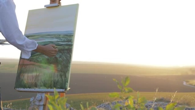 蓝天和乡村景观背景下的艺术家肖像。