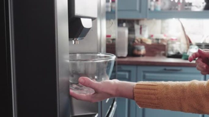 用冰箱制冰机的冰块装满碗，以准备茶点饮料。