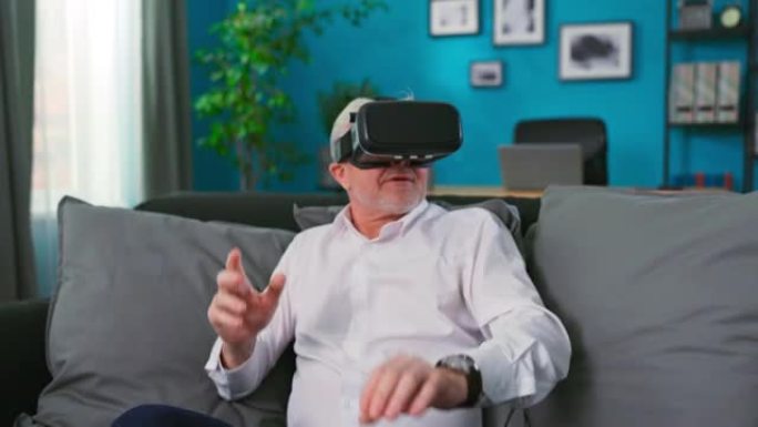 快乐的老爷爷戴上vr眼镜。男子在虚拟耳机眼镜观看惊人的3d视频在360 vr头盔在家里。穿着VR护目