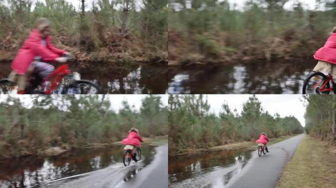 漂亮的年轻女孩在洪水泛滥的小路上骑自行车
