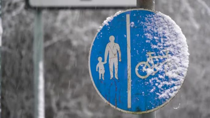 落雪中的蓝色共享人行道标志