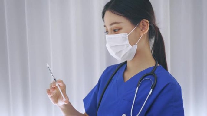 近距离的女性亚洲医生持有疫苗注射针准备接种疫苗。年轻的医学实验室技术员在工作