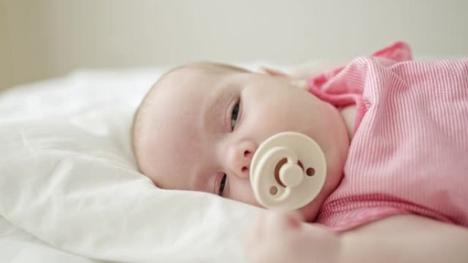 婴儿在床上用奶嘴慢慢入睡