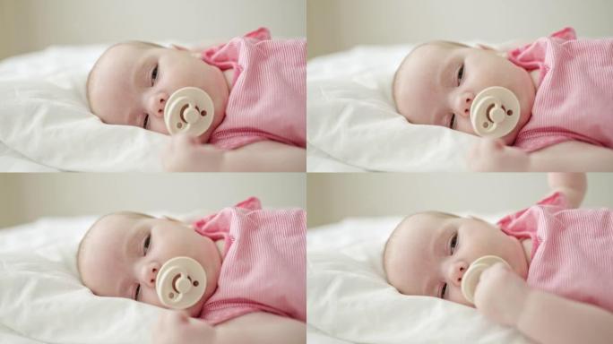 婴儿在床上用奶嘴慢慢入睡