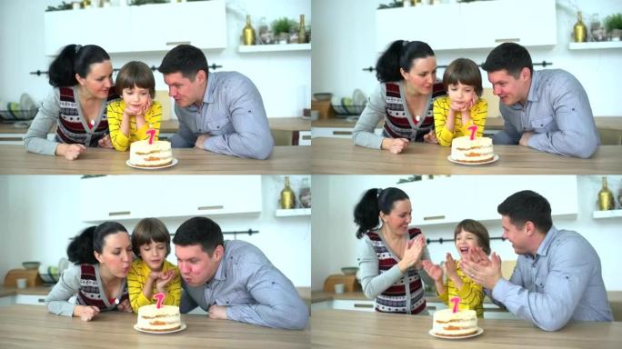 非常可爱的男孩用蛋糕庆祝他的生日 & 快乐的父亲和母亲。7年。小男孩在家吹灭生日蛋糕上的蜡烛。快乐的