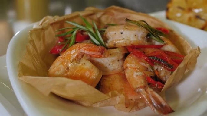 在一家餐馆的盘子上放有虾和迷迭香的菜的特写镜头。
